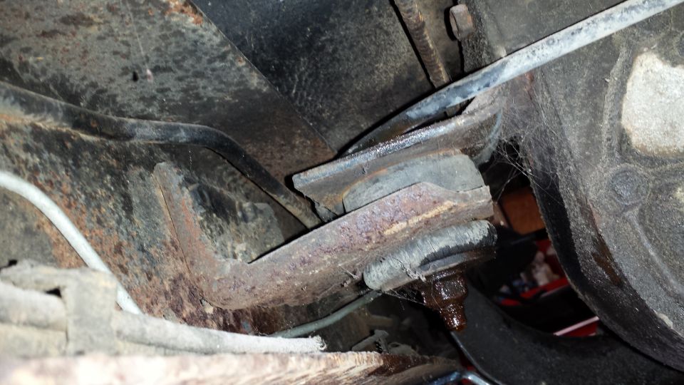 Close-up of rusty suspension part with cobwebs
