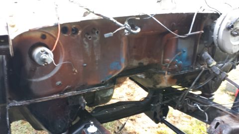 1978 Ford Bronco - The engine bay of a vehicle is shown, with visible rust and exposed wiring.