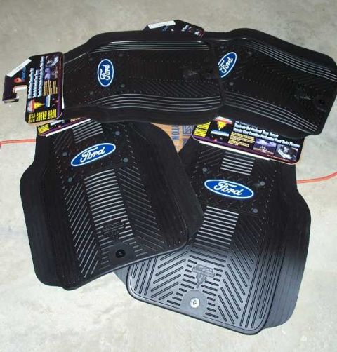 1998 Ford Crown Victoria - Set of black Ford floor mats with blue oval logos and textured surfaces.