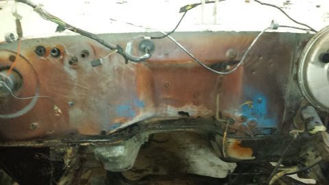 1978 Ford Bronco - The rusted engine bay firewall shows signs of wear and tear, with exposed wiring and mounting points.