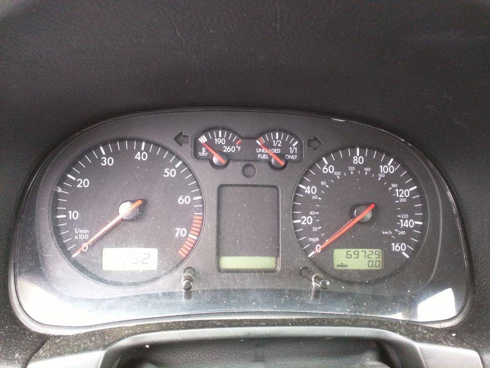 Car dashboard with speedometer, tachometer, fuel gauge, and temperature gauge. Odometer shows 69729 miles