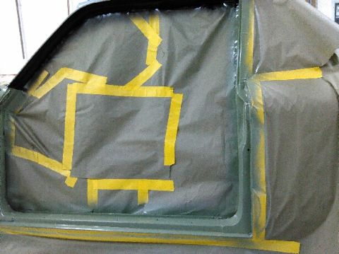 1960 Ford Ranchero - Car door window masked with brown paper and yellow tape, likely for painting.