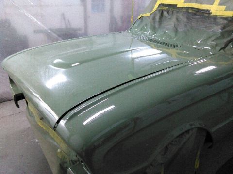 1960 Ford Ranchero - The front end of a car is being prepped for painting, with masking tape covering the windshield area.