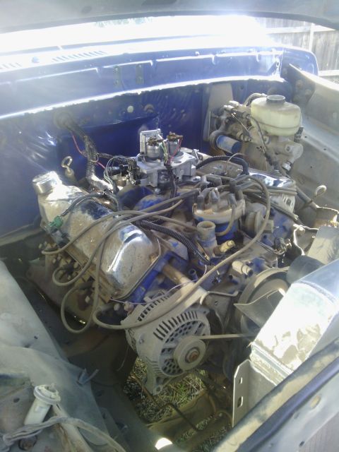 1978 Ford Bronco - The engine bay of a 1978 Ford Bronco shows a V8 engine with chrome valve covers and blue accents.