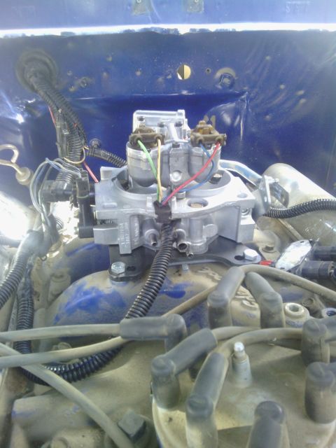 1978 Ford Bronco - Close-up view of an engine's carburetor assembly, with wiring and engine components visible.