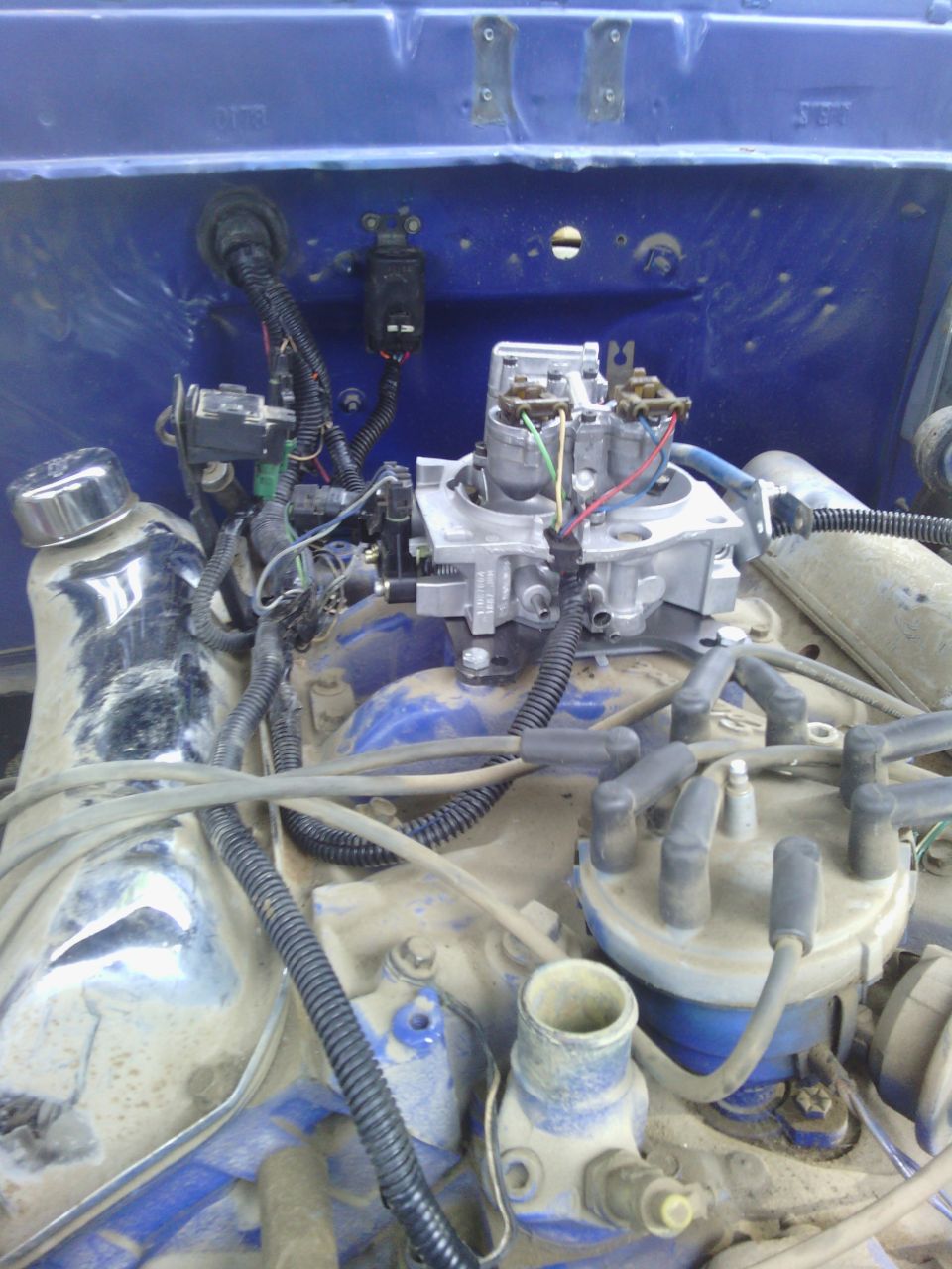 close-up of engine bay showing carburetor, distributor, and wiring