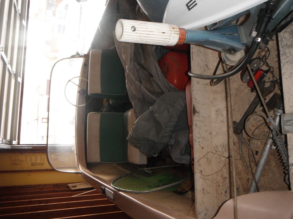 Boat interior with seats, fishing net, and outboard motor controls visible