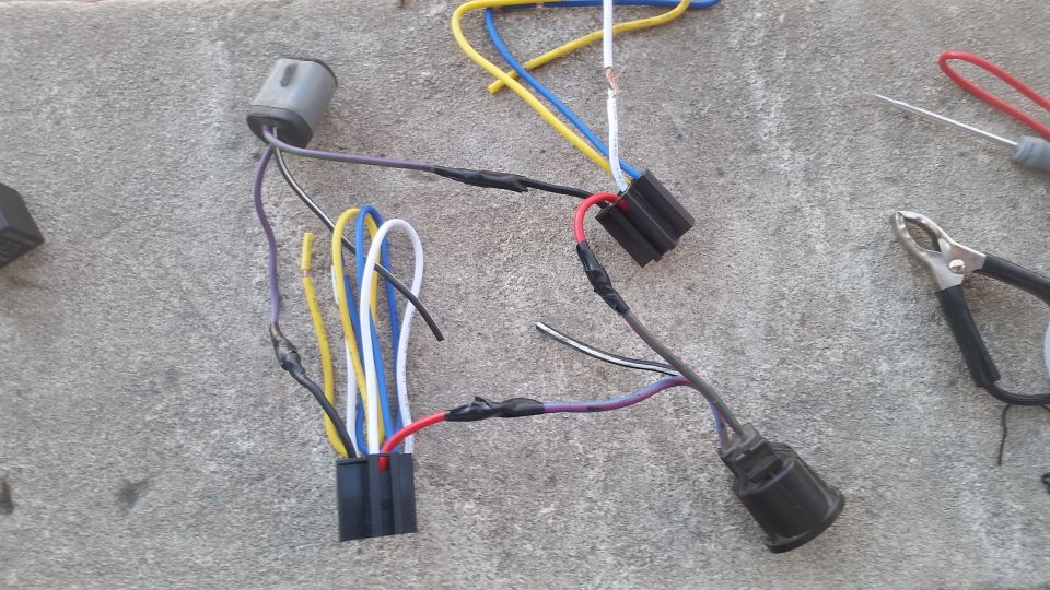 Automotive wiring harness with multiple colored wires and connectors on a concrete surface