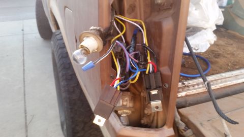 1985 Ford Bronco - Exposed wiring and relays are visible in the tail light assembly of a vehicle, suggesting a repair or modification.