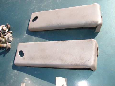 1973 Ford Ranchero - Two beige plastic trim pieces and a collection of screws are laid out on a teal surface.