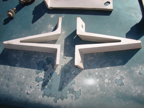 1973 Ford Ranchero - Metal brackets and hardware are arranged on a weathered teal surface.