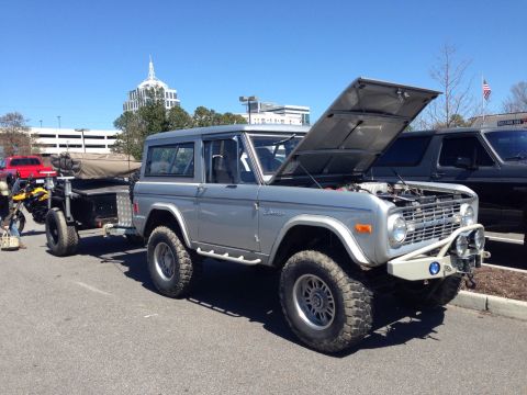 1979 Ford Bronco - This silver 1979 Ford Bronco is shown with its hood open and is towing a trailer.