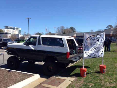 1979 Ford Bronco - A lifted Ford Bronco is parked next to a flag displaying "Tidewater Broncos" and a drawing of an older Bronco.