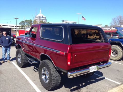 1979 Ford Bronco - Lifted 1978 Ford Bronco in a parking lot with a man standing nearby.