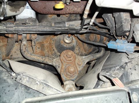 1999 Mercury Grand Marquis - Close-up view of engine and suspension parts, showing rust and wiring.