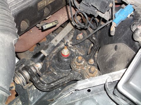 1999 Mercury Grand Marquis - Close-up view of engine bay components, including suspension parts and exhaust manifold.