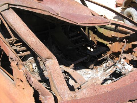 1994 Ford Bronco - The interior of this vehicle is severely damaged and rusted, obscuring any identifying features or year.