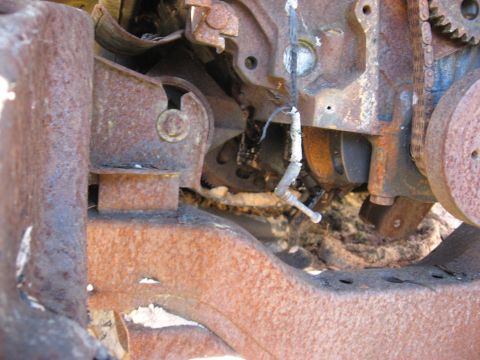 1994 Ford Bronco - Close-up view of heavily corroded engine parts and vehicle frame.