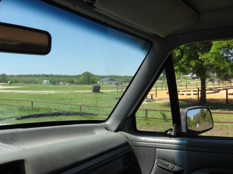 1994 Ford Bronco - View from inside a vehicle looking out at a rural landscape with a fence and trees.