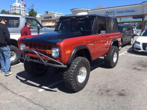 1979 Ford Bronco - This red 1979 Ford Bronco features a black hood and aggressive off-road tires.