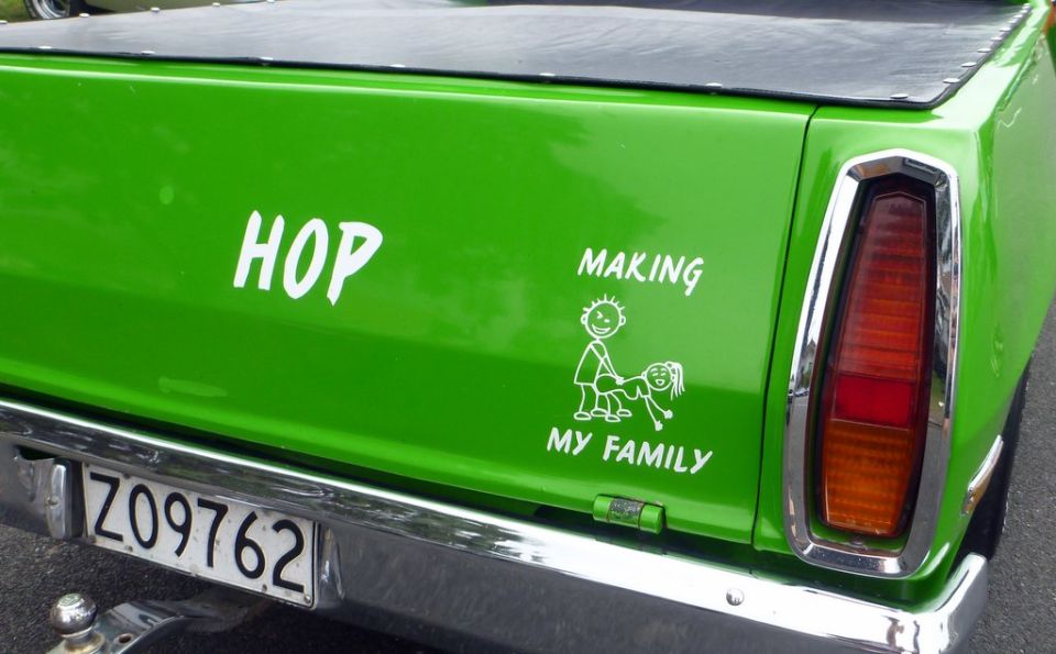 Green pickup truck tailgate with 'HOP' and 'MAKING MY FAMILY' stickers and a license plate Z09762
