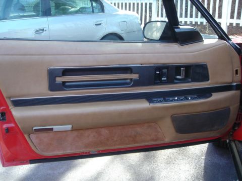 1991 Buick Reatta - Interior door panel detail with another vehicle visible outside.