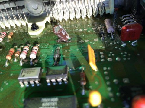 1995 Ford Bronco - Close-up view of electronic components on a green circuit board, including resistors and capacitors.