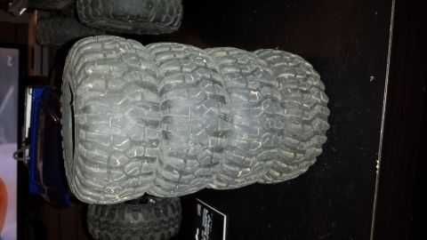 1993 Toyota 4Runner - Several off-road tires are stacked on a dark surface, with a "SUPERMOTORS.NET" logo visible.