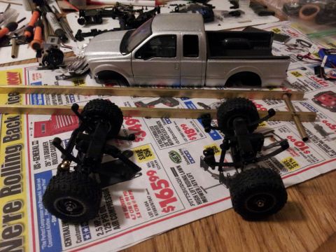 1995 Ford Bronco - Model truck body and chassis are laid out on a surface covered with newspaper, suggesting a hobbyist's project.