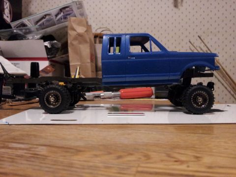 1995 Ford Bronco - A partially assembled model truck sits on a workbench, showing its chassis and cab.