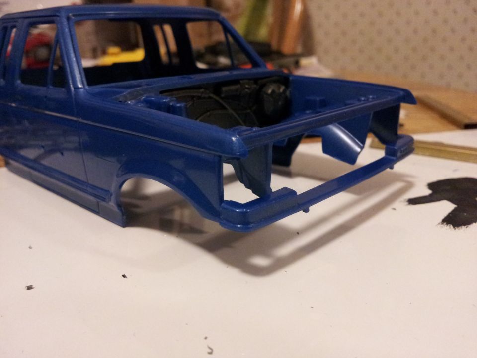 Blue model truck body, front view, unpainted engine detail