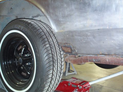 1973 Ford Ranchero - A close-up view of the side of a 1973 Ford Ranchero, highlighting the wheel well, tire, and a section of the body undergoing repair.