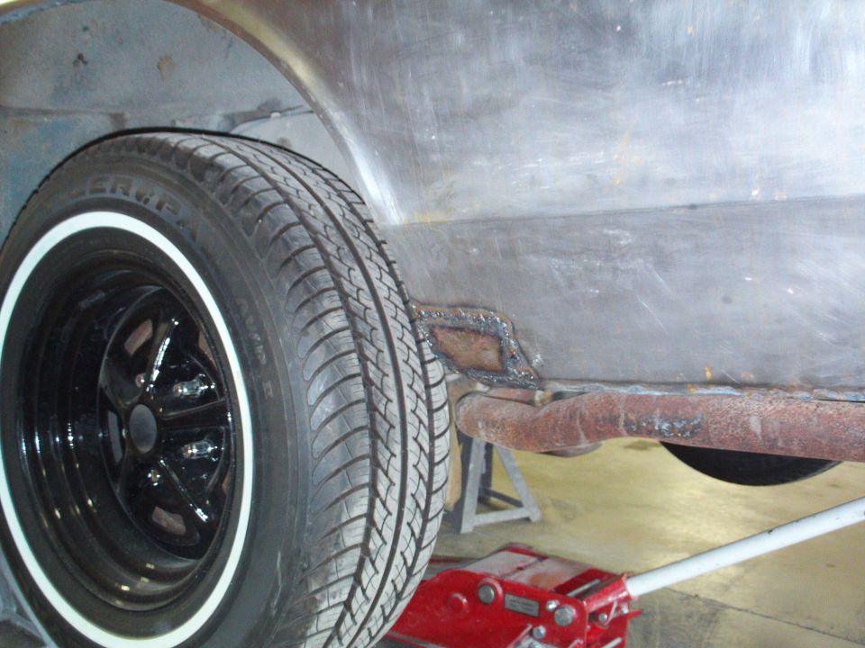 1973 Ford Ranchero side view showing wheel well, tire, and rusted metal panel with patch