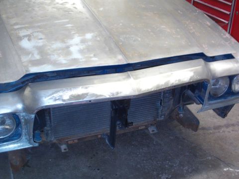 1973 Ford Ranchero - The front end of a car is shown with the hood and grille removed, revealing the radiator and headlights.