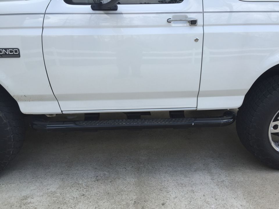 White 1995 Ford Bronco side view showing door, running board, and tire