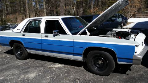 1991 Ford LTD Crown Victoria - This sedan has a two-tone paint scheme and its hood is open, revealing the engine compartment.