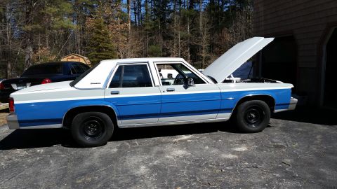 1991 Ford LTD Crown Victoria - This sedan has a distinctive two-tone paint scheme with a blue stripe separating the gray upper and lower sections.