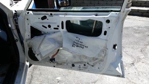 1991 Ford LTD Crown Victoria - Interior of a white car door showing insulation and wiring, with visible text on the insulation.