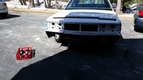 1991 Ford LTD Crown Victoria - A white sedan is parked outside with its front end disassembled, revealing the engine bay and frame.