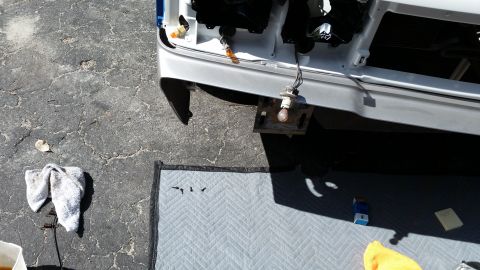 1991 Ford LTD Crown Victoria - Front end of a car undergoing repair, with parts laid out on a protective mat.