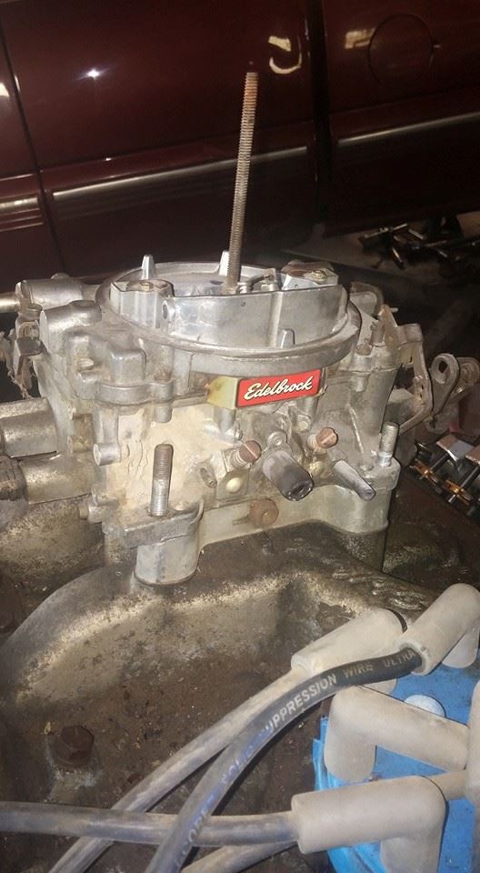 Edelbrock carburetor with red label and visible spark plug wires