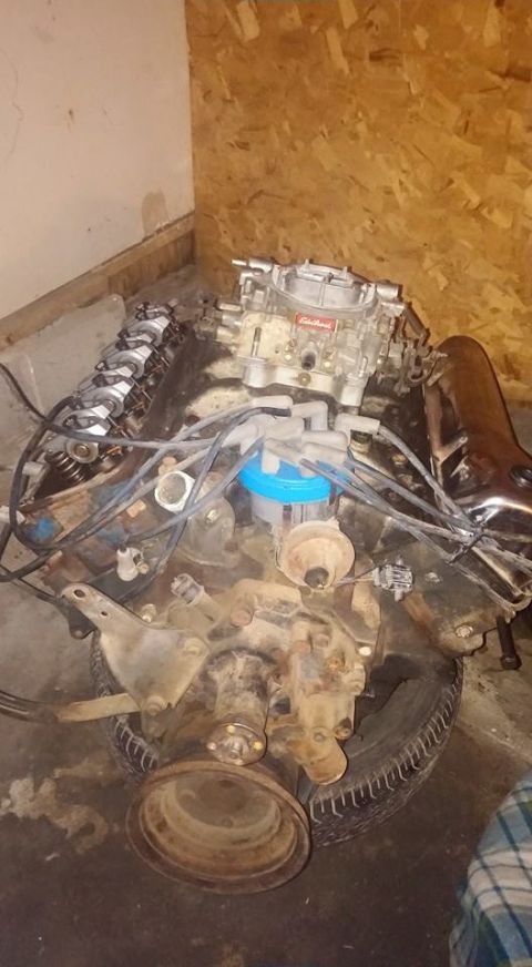 1979 Ford Bronco - Engine assembly with carburetor and distributor cap, likely a V8, is shown in a storage area.