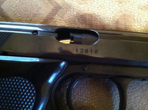 1976 Dodge Power Ram - Close-up of a pistol's slide shows a serial number and a website watermark.