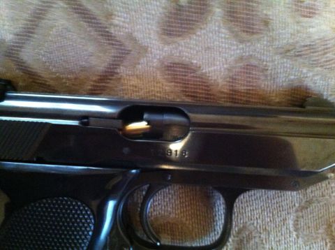 1976 Dodge Power Ram - A close-up view of a pistol's slide, showing the serial number 2918 and a round loaded in the chamber.