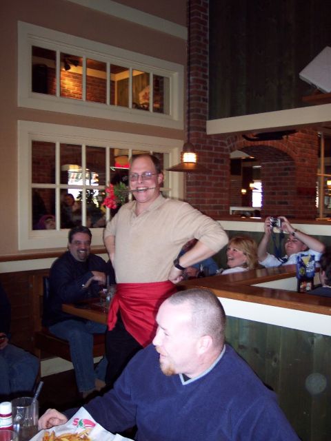 2001 Ford Crown Victoria - People gathered inside a restaurant with brick accents and wooden booths.