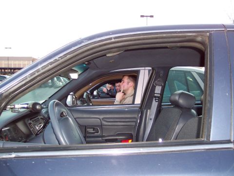 2001 Ford Crown Victoria - Interior view of a dark blue 2001 Ford Crown Victoria with two men inside.
