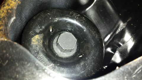 1991 Buick Reatta - A close-up view of a bolt head on a black metal component, likely from a vehicle's chassis or suspension system.