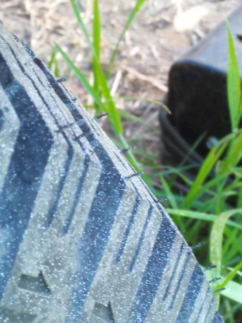 1991 Ford Bronco - A close-up view of a tire's tread pattern is visible, with grass and a dark object in the background.