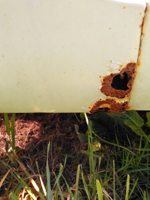 1991 Ford Bronco - This close-up shows significant rust damage on a vehicle's body panel, indicating wear and tear.