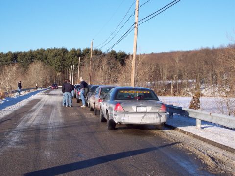 2001 Ford Crown Victoria - Several Ford Crown Victoria police cars are parked on a road with snow on the ground.